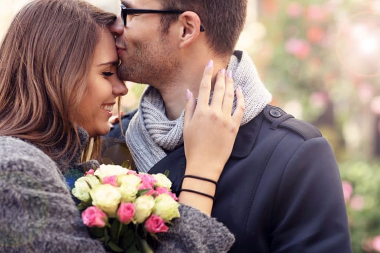cute man and woman embracing after she receives flowers for Valentine's Day