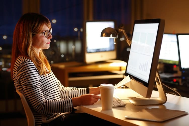 pretty middle age woman working late at an office computer - high-functioning